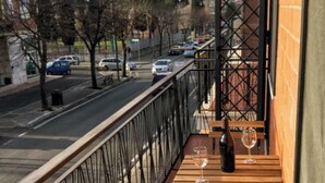 Ein Balkon mit Blick auf eine Straße und geparkte Autos.