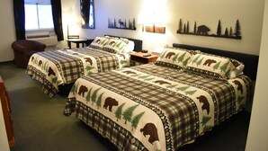 Une chambre d’hôtel avec deux lits, une chaise, un bureau et une fenêtre avec des rideaux.