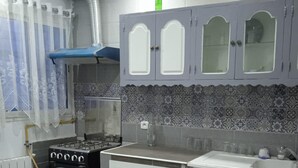Une cuisine avec des meubles de couleur grise, une cuisinière et un évier.