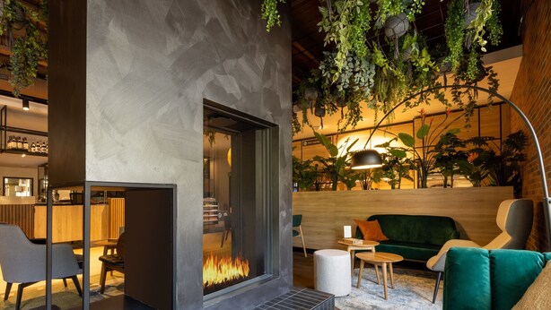 A modern interior with a fireplace, seating area, and indoor plants. - Bungalow in Park De Peel - Car-free Retreat (Vlierden)