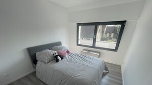 Ein Schlafzimmer mit Bett, Kissen, Heizung und Fenster.