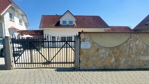 Zona residencial privada con un muro de piedra y un cartel que indica 'BEX CITY APARTMENTS'.