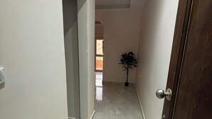 A hallway with marble flooring, a wooden door, and a potted plant. - Wake up looking at the Red Sea! (Hurghada)