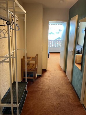 A hallway with a wooden bench, a coat rack, and a small table. - 50m from resort center, 2nd floor, balcony, tv, 27m², Val Thorens (Val Thorens)
