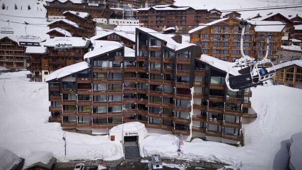 Ein großes, mehrstöckiges Hotel mit einer Seilbahn im Hintergrund.
