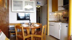 A compact kitchen with a dining table set for four, a built-in oven, and a refrigerator. - 10m from ski slopes, 3rd floor, tv, ski locker, 21m², Avoriaz (Avoriaz)