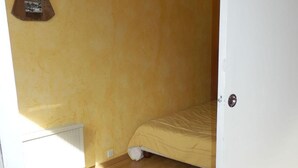 A room with a bed, a radiator, and a wooden angel decoration on the wall. - 50m from ski slopes, 6th floor, view resort, balcony, tv, ski locker, 32m², Avoriaz (Avoriaz)