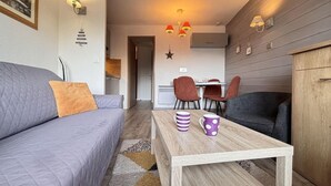 Ein gemütliches Wohnzimmer mit einer Couch, einem Couchtisch und einem Essbereich mit Stühlen.