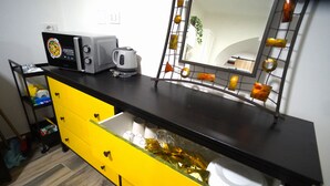 A kitchen with a microwave, kettle, and a mirror with decorative lights. - Apartment Lallarella 17: historic center of Naples (Napoli)