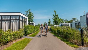 A pathway flanked by greenery and modern buildings, likely part of a residential or commercial complex. - Enchanting Chalet 600 m From the sea (Breskens)