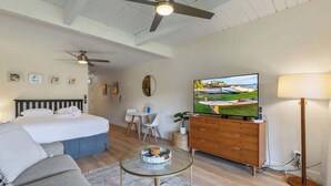 A bedroom with a bed, a TV, a dresser, and a ceiling fan. - Remodeled Ground floor studio, AC, across from the beach, close to everything (Kihei)