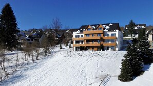 A multi-story residential building with a modern architectural design, featuring balconies and a sloped roof. - Nice Apartment With Dishwasher, in a Residence 500 m. From the ski Lift (Winterberg)
