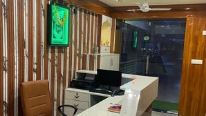 Ein modernes Büro mit einem Marmor-Empfangstresen, Holzwandverkleidung und einem Deckenventilator.