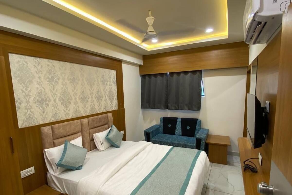 Ein modernes Hotelzimmer mit einem großen Bett, einem Schreibtisch und einem Deckenventilator.