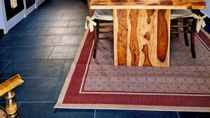 Een landelijke keuken met een houten tafel, een hanglamp en een raam met uitzicht.