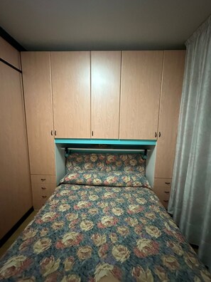 Ein Schlafzimmer mit Bett, Kopfteil und Holzschränken.