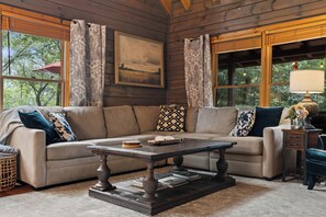 A cozy living room with a sectional sofa, a coffee table, and a lamp.