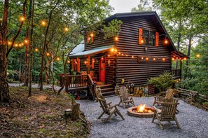 A log cabin with a porch, outdoor seating, and a fire pit. - Secluded Cherry Log Cabin - Sauna - Hot Tub - Putting Green (Blue Ridge)