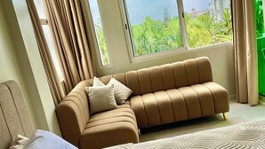 A hotel room with a large bed, a sofa, and a window with curtains. - Résidence Beach palace 1, apartment at the beach  (Mohammédia)