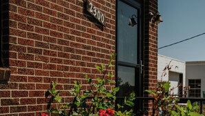 A brick building with a black door and a number plate reading "2300".