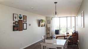 Un comedor con una mesa y sillas, un televisor en la pared y una lámpara en el techo.