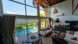 A spacious living area with a pool view, modern kitchen, and large windows. - Trio Palazio Sapanca (Sapanca)