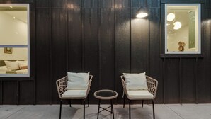 A dark wooden wall with two wicker chairs and a small round table. - New Guesthouse w/ Private Patio, Fast WiFi, 1 bed/1 bath (Edmond)
