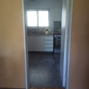 Eine Küche mit weißen Schränken, einem Herd und einem Fenster.