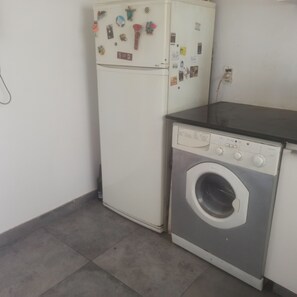 Eine kleine Küche mit Kühlschrank und Waschmaschine.