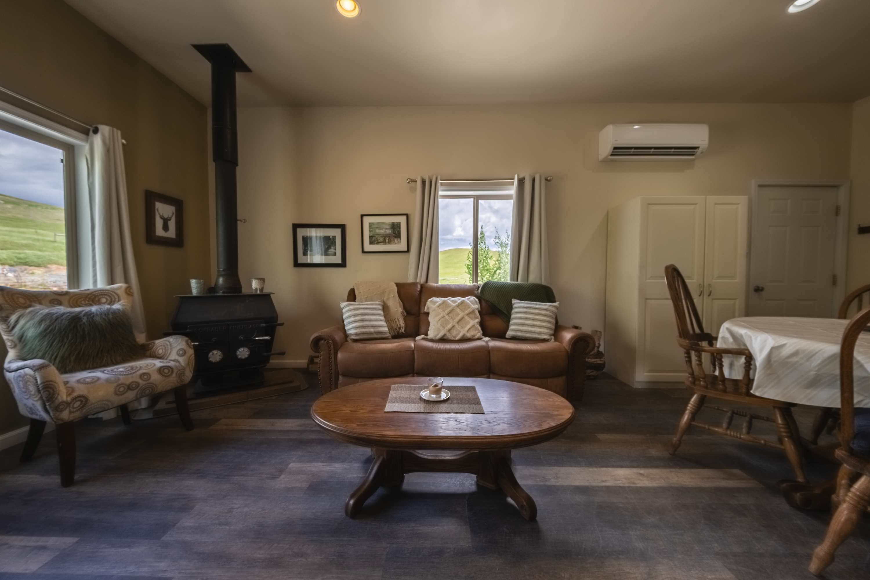 A cozy living room with a fireplace, a sofa, a coffee table, and a dining table.
