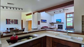 A spacious kitchen with a large island, a dining area, and a fireplace. - Sedona Sunrise (Sedona)