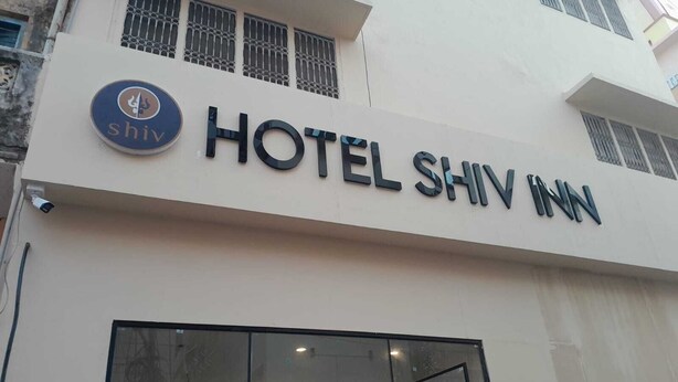 A hotel sign with the name "HOTEL SHIV INN" and a logo with a trident symbol. - Hotel Shiv Inn By T And M Hotels (Haridwar)