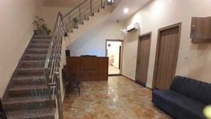 A hotel lobby with a marble floor, a staircase, a reception desk, and a sofa. - Hotel Shiv Inn By T And M Hotels (Haridwar)
