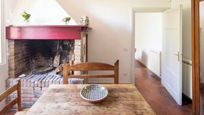 Ein gemütliches Zimmer mit einem Kamin aus Ziegelsteinen, einem Holztisch und einem Stuhl.