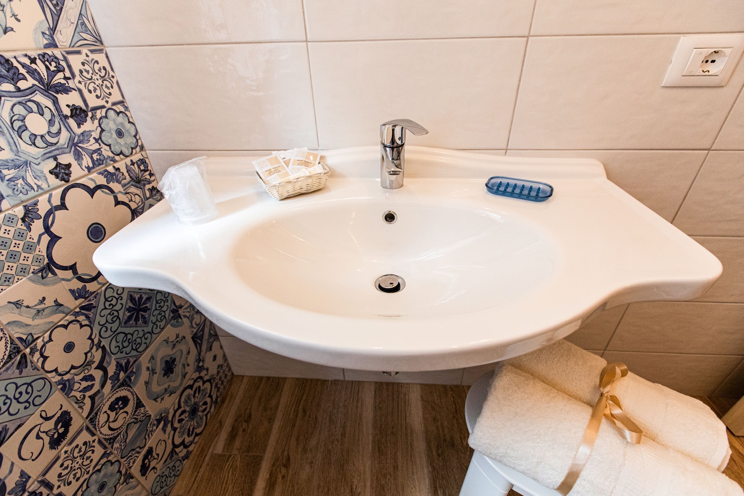 Une salle de bain avec un lavabo blanc, une brosse à dents bleue et une serviette blanche.
