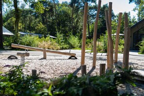 A seesaw in a park with wooden posts and a sandy ground. - Eco Villa in Latour by Scenic Pond (Oirschot)
