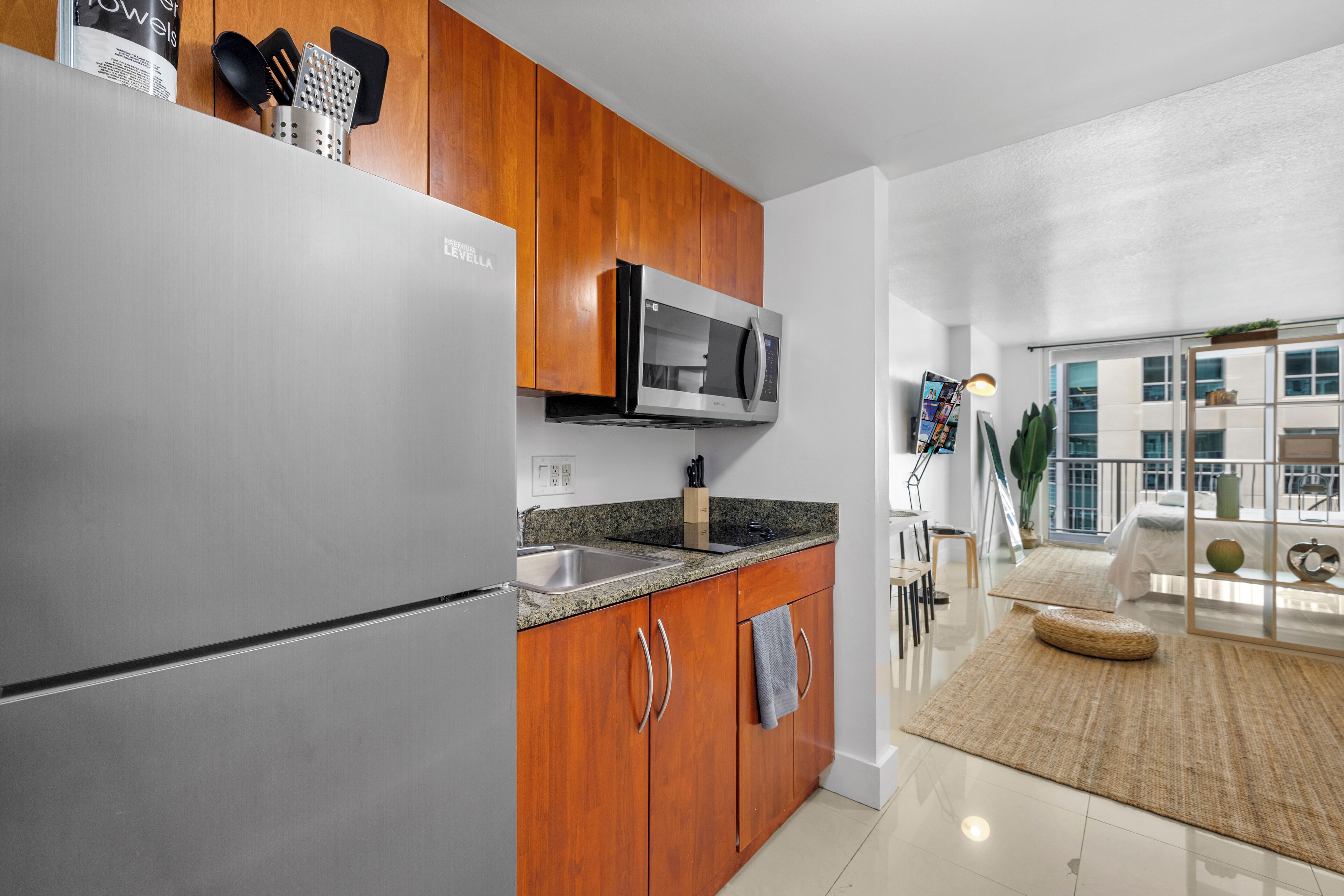 A modern kitchen with wooden cabinets, stainless steel appliances, and a granite countertop.