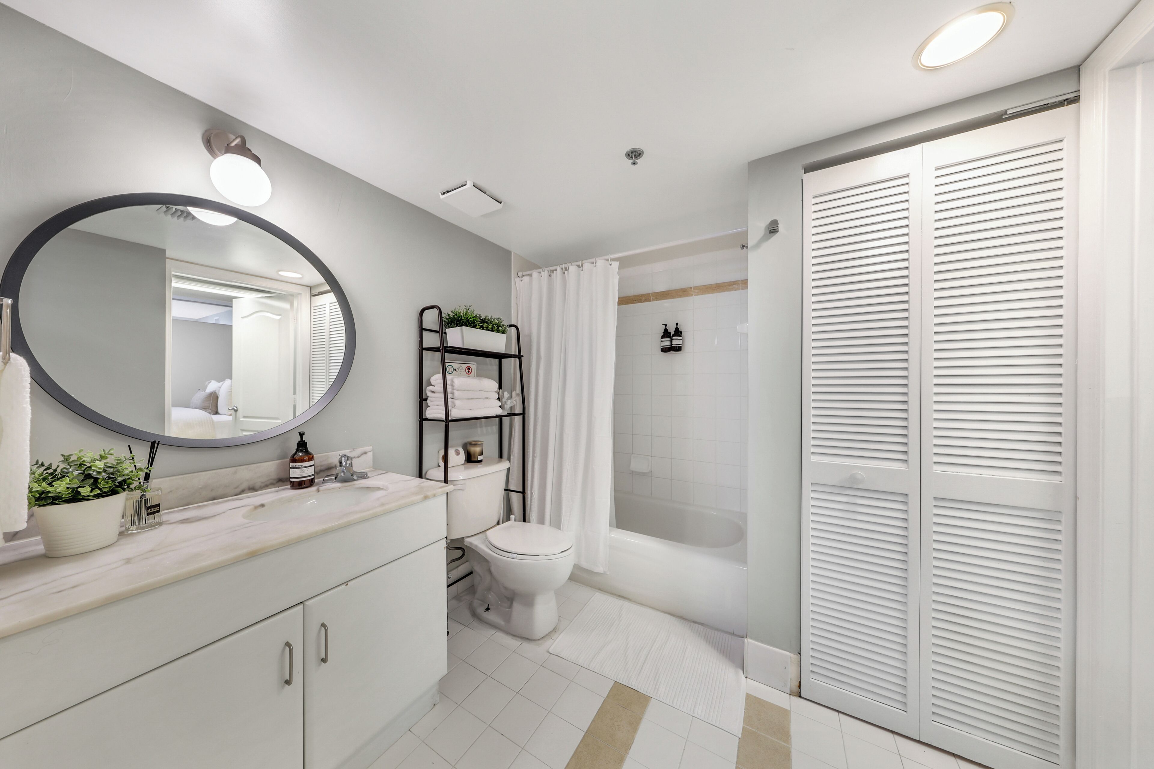 Une salle de bain moderne équipée de toilettes, d’un lavabo, d’un miroir et d’une douche.