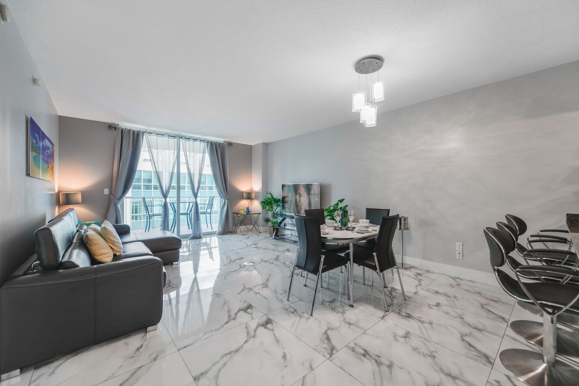 Een moderne woonkamer met een marmeren vloer, een bank, een eettafel met stoelen en een groot raam met gordijnen.