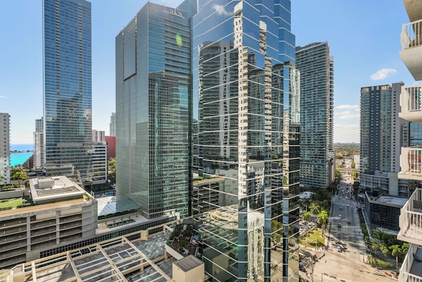 A high-rise building with a modern glass facade, surrounded by other tall buildings. - Modern Condos Available in Brickell (Miami)