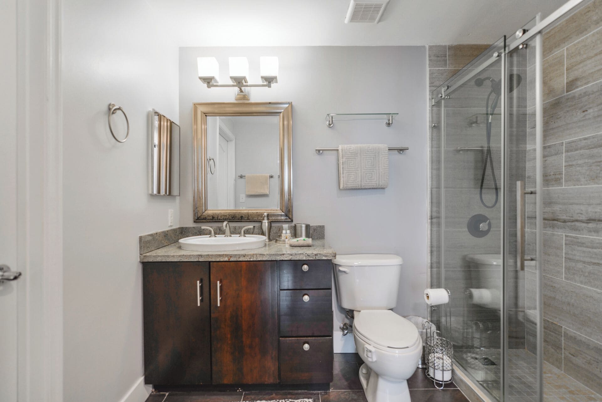 Une salle de bain moderne avec un meuble-lavabo, des toilettes et une douche à parois de verre.