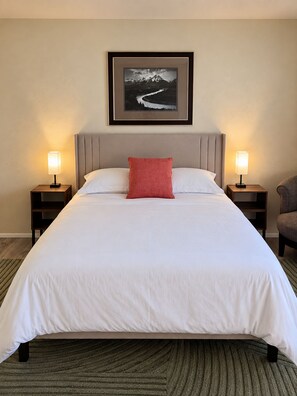 A hotel room with a bed, two bedside lamps, a framed picture on the wall, and a patterned carpet. - Scenic getaway in central Flagstaff (Flagstaff)