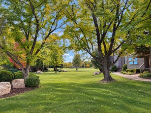 A well-maintained lawn with mature trees and a building with a visible address. - Scenic getaway in central Flagstaff (Flagstaff)
