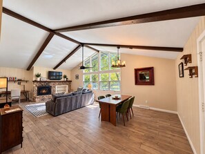 A spacious living area with a fireplace, a dining table, and a large window providing natural light. - Scenic getaway in central Flagstaff (Flagstaff)