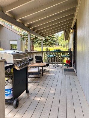 A covered outdoor area with a grill, seating, and a view of a yard. - Scenic getaway in central Flagstaff (Flagstaff)