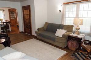 A living room with a sofa, a lamp, a rug, and a wooden table.