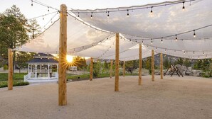 An outdoor pavilion with a white gazebo in the background, surrounded by a sandy area and trees. - THE Cottage #2504 (Big Bear City)
