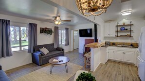 A living room with a sofa, coffee table, and a ceiling fan. - THE Cottage #2504 (Big Bear City)