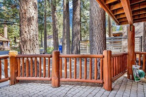 A wooden deck with a metal fence, surrounded by tall trees. - OUR Cabin IN THE Woods #2476 (Big Bear Lake)