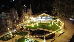 A house with a well-lit driveway, a lawn, and a small pond. - THE Ranch House #2501 (Big Bear City)